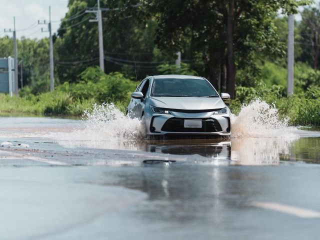 冠水している道路を走っているイメージ画像